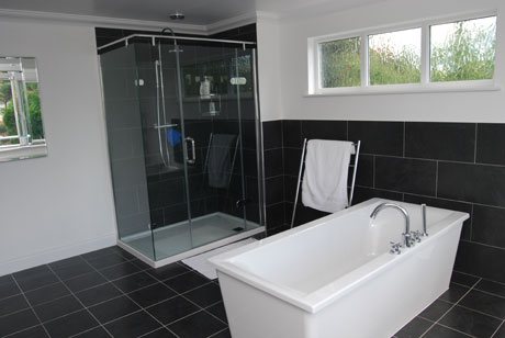 Slate-tile bathroom with separate shower and freestanding bath